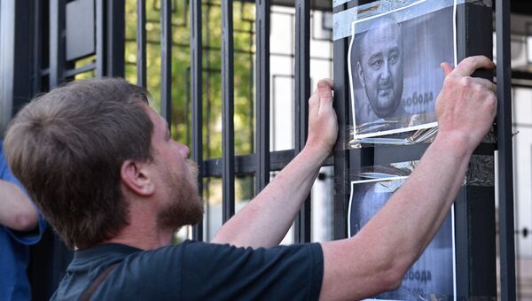 Мужчина клеит листовки с портретом убитого российского журналиста Аркадия Бабченко у здания посольства РФ в Киеве. 30 мая 2018