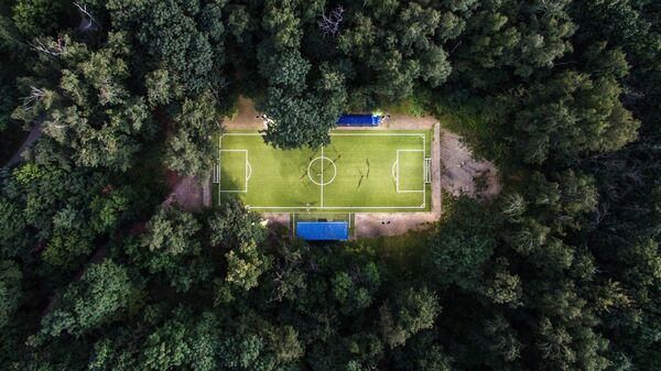 Люди играют в футбол в Нескучном саду в Москве