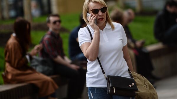 Женщина говорит по телефону на улице Москвы. Архивное фото