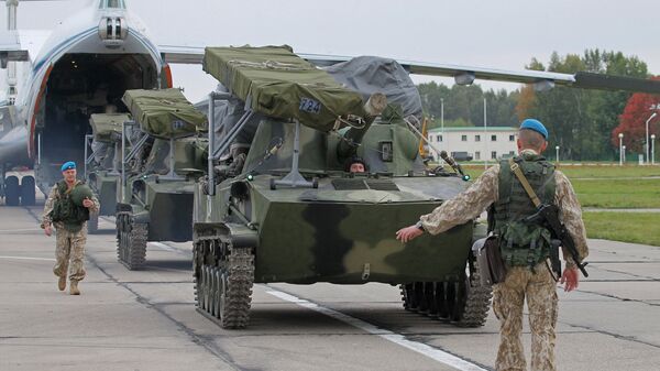 Российской военнослужащие выгружают бронетехнику из транспортного самолета ИЛ-76