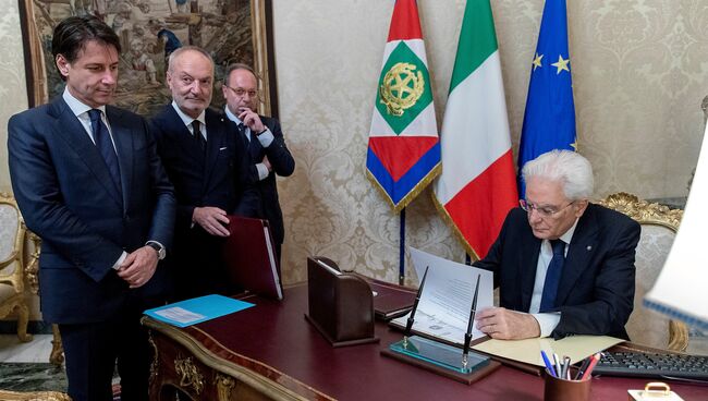 Назначенный премьер-министром Италии Джузеппе Конте смотрит, как президент Италии Серджо Маттарелла подписывает документы, Италия. 31 мая 2018