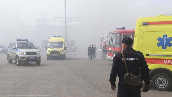 Автомобили скорой помощи, сотрудники полиции и пожарная техника перед зданием торгового центра Порт в Казани, где произошло возгорание. 5 июня 2018