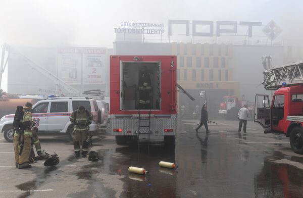 Сотрудники МЧС и пожарная техника перед зданием торгового центра Порт в Казани, где произошло возгорание. 5 июня 2018 Сотрудники МЧС и пожарная техника перед зданием торгового центра Порт в Казани, где произошло возгорание. 5 июня 2018