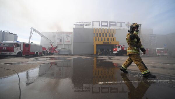 Сотрудники МЧС и пожарная техника перед зданием торгового центра Порт в Казани, где произошло возгорание.  5 июня 2018