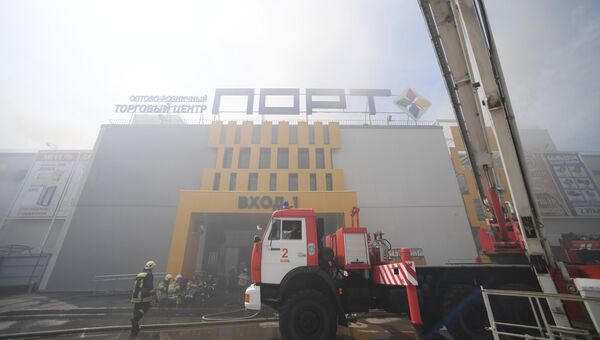 Сотрудники МЧС и пожарная техника перед зданием торгового центра Порт в Казани.  5 июня 2018