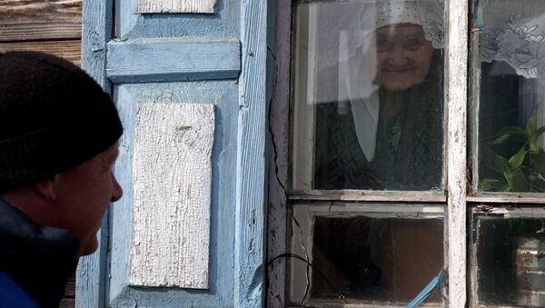 Работник службы социальной поддержки у дома одной из своих подопечных в селе Екатерининское