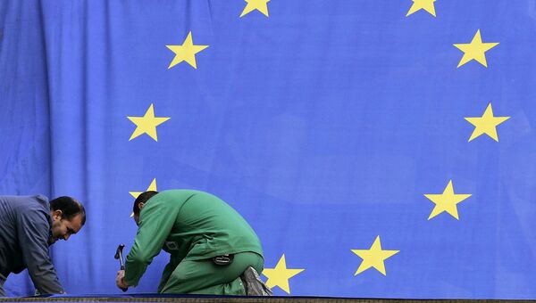 Рабочие прикрепляют флаг Европейского союза возле штаб-квартиры ЕС в Брюсселе