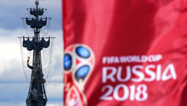 Флаг с символикой чемпионата мира по футболу 2018 на фоне памятника В ознаменование 300-летия российского флота (Петру I)