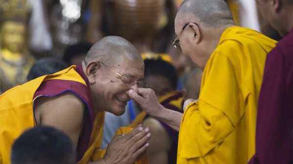 Далай-лама держит монаха на нос во время визита в Дхармсале