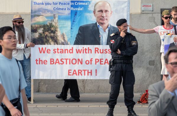 Жители Австрии держат плакат с изображением Владимира Путина во время его встречи с президентом Австрии Александром Ван дер Белленом в Вене