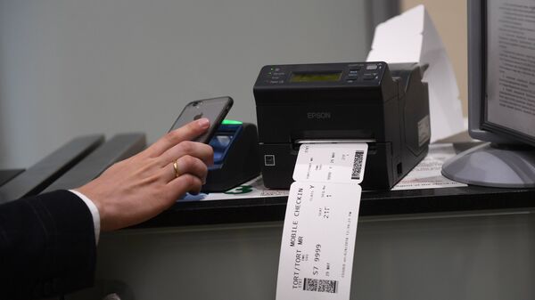 Пассажир сканирует и распечатывает посадочный талон в аэропорту 