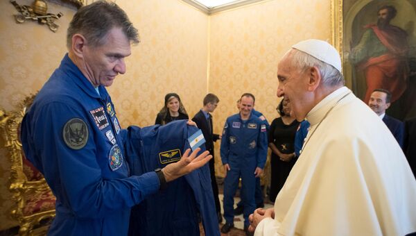 Астронавт Поало Несполи вручает костюм космонавта МКС Папе Римскому Франциску. 8 июня 2018