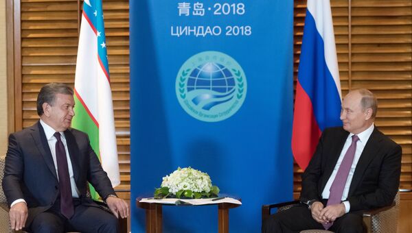 Владимир Путин и президент Республики Узбекистан Шавкат Мирзиёев во время встречи на полях саммита ШОС. 9 июня 2018