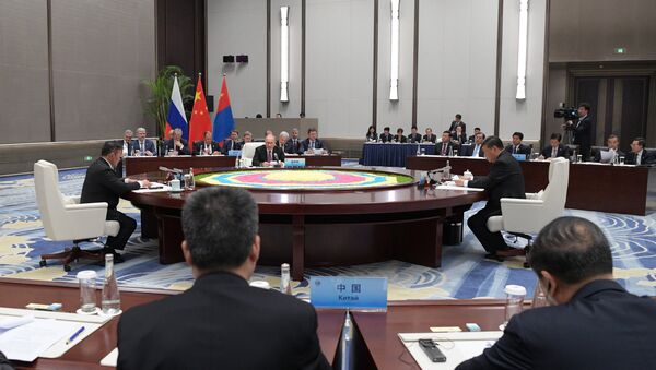 Владимир Путин во время встречи с председателем КНР Си Цзиньпинем и президентом Монголии Халтмаагийном Баттулгой на полях саммита ШОС. 9 июня 2018