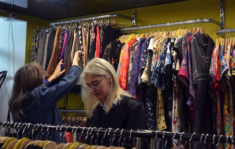 посетители выбирают одежду в винтажном магазине Желтая вешалка