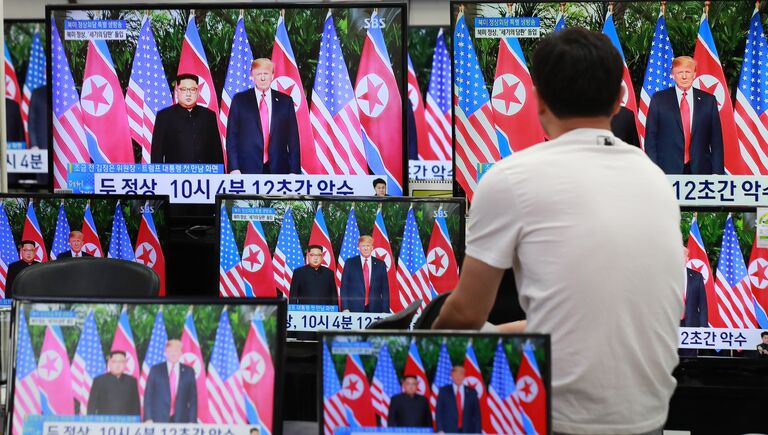 Трансляция встречи президента США Дональда Трампа и лидера КНДР Ким Чен Ына в магазине электроники в Сеуле, Южная Корея. 12 июня 2018