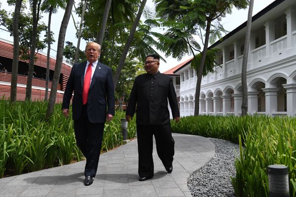 Президент США Дональд Трамп и лидер КНДР Ким Чен Ын во время прогулки у отеля Капелла в Сингапуре. 12 июня 2018