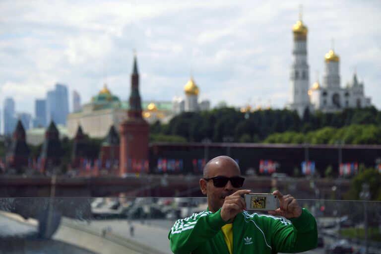 Болельщик чемпионата мира по футболу 2018 фотографируется на фоне Кремля в Москве Болельщик чемпионата мира по футболу 2018 фотографируется на фоне Кремля в Москве