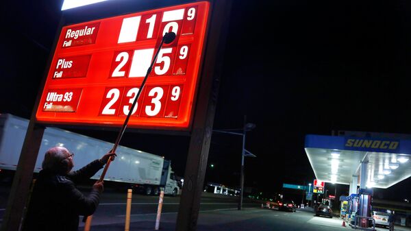Мужчина меняет цены на бензин на АЗС в американском городе Форт Ли