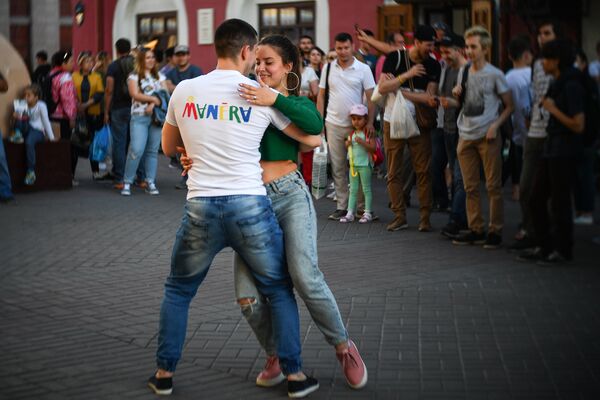 Пара туристов танцует на улице Баумана в Казани