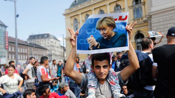 Мигрант с фотографией Ангелы Меркель в Будапеште. Архивное фото