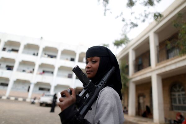Девушка с игрушечной винтовкой в школе для внутренне перемещенных лица Йемене