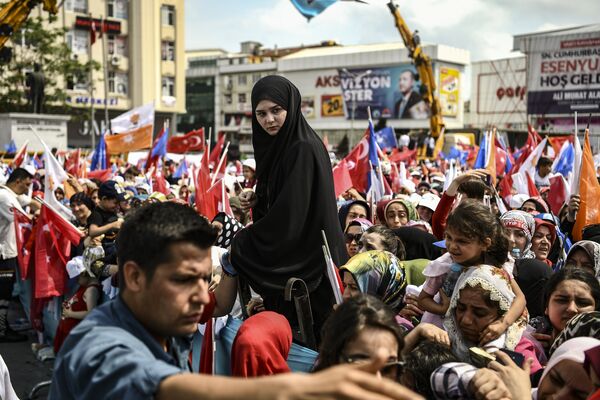 Жители Стамбула слушают речь президента  Реджепа Тайипа Эрдогана накануне выборов в Турции