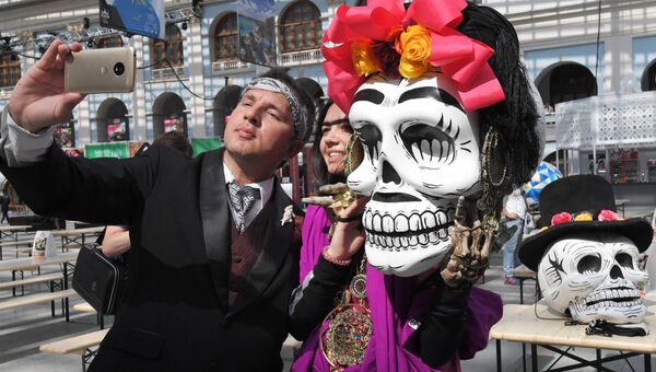 Участники карнавала, проходящего в рамках празднования традиционного мексиканского праздника День мертвых, в Москве