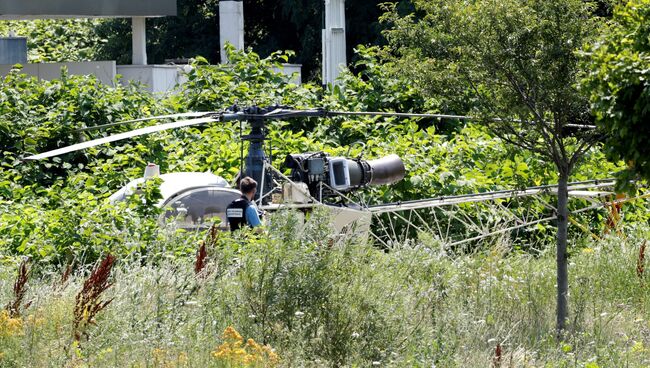 Сотрудник правоохранительных органов Франции возле брошенного вертолета. 1 июля 2018