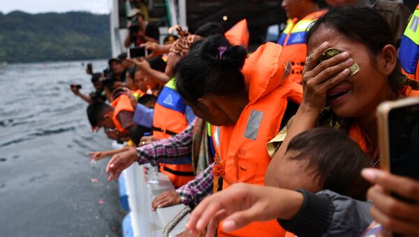 Родственники пропавших пассажиров во время посещения места крушения парома на озере Тоба в Сималунгуне, Индонезия. 2 июля 2018