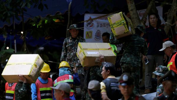 Солдаты и спасатели несут коробки с необходимыми вещами в пещеру Тхам Луанг в провинции Чиангмай, Таиланд. 4 июля 2018 года