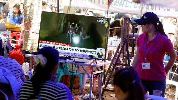 Члены семьи смотрят трансляцию из пещеры Тхам Луанг, где находятся мальчики и тренер. 4 июля 2018 года