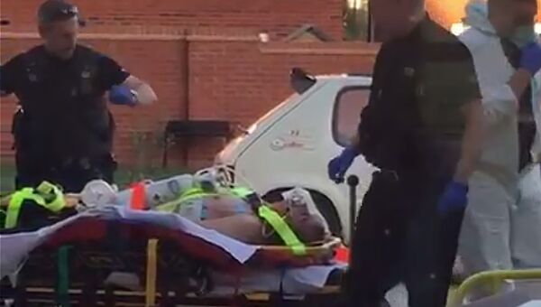 Сотрудники скорой помощи увозят мужчину из жилого дома в британском Эймсбери. 30 июня 2018