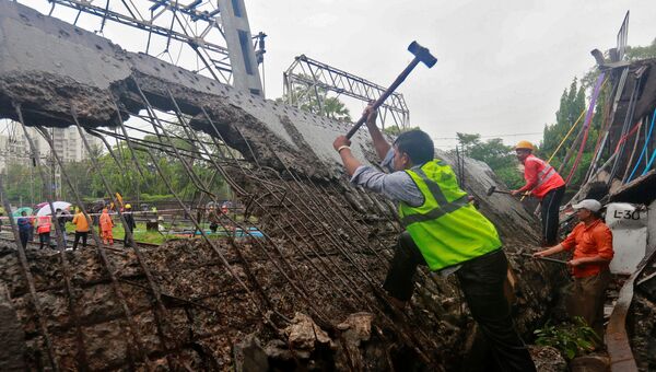 Спасатели и железнодорожники на месте обрушения пешеходного моста  результате проливных дождей в Мумбаи. 3 июля 2018 года