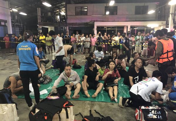 Сотрудники экстренных служб Таиланда оказывают помощь спасенным пассажирам перевернувшихся в районе Пхукета туристических лодок. 5 июля 2018