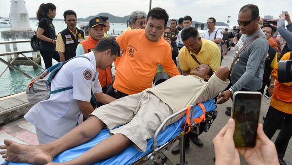 Спасатели оказывают помощь пассажиру перевернувшейся туристической лодки на Пхукете, Таиланд. 6 июля 2018
