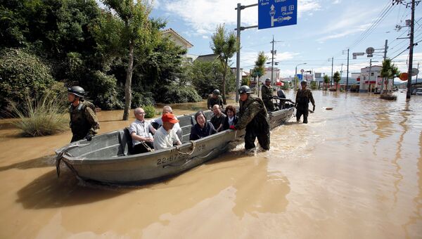 Cпасатели эвакуируют местных жителей из затопленного района в Курасики, Япония. 8 июля 2018
