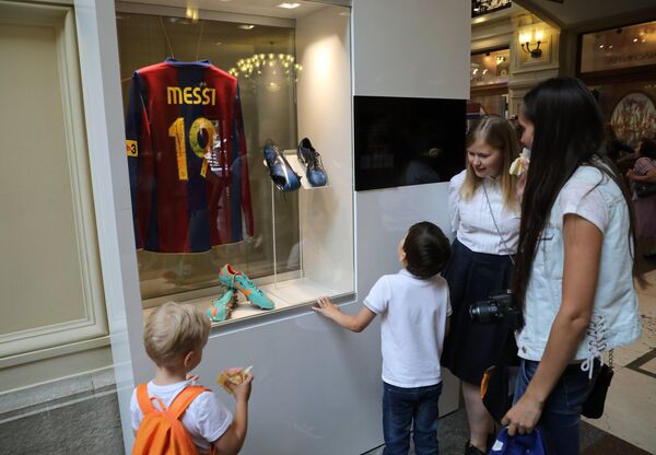 Посетители возле витрины с формой и бутсами футболиста сборной команды Аргентины Лионеля Месси, представленные на выставке футбольной атрибутики Qatar @RoadTo2022 Exhibition в ГУМе в Москве