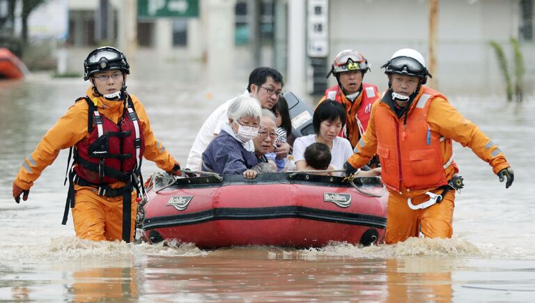Спасатели эвакуируют жителей из Курасики, префектура Окаяма, Япония. 8 июля 2018 года