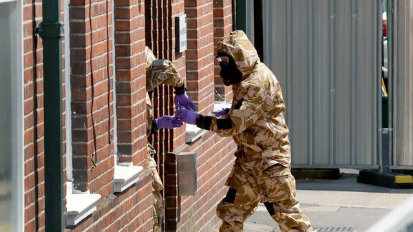 Сотрудники британских спецслужб в защитных костюмах у жилого дома в Солсбери в связи с расследованием отравления людей в Эймсбери