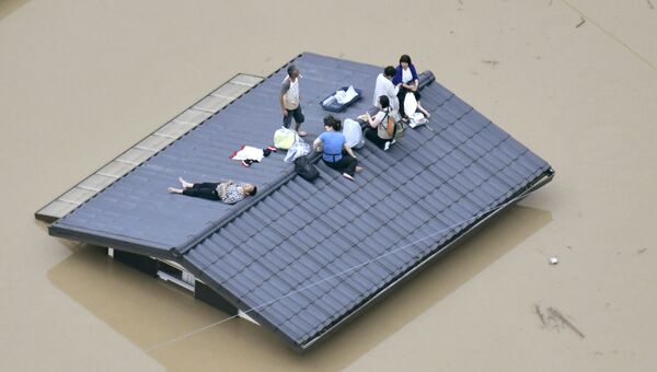 Жители города Курасики ждут спасателей во время наводнения в Японии. 7 июля 2018 года