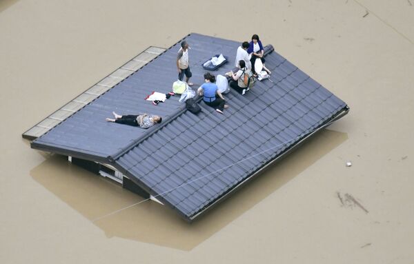 Жители города Курасики ждут спасателей во время наводнения в Японии. 7 июля 2018 года