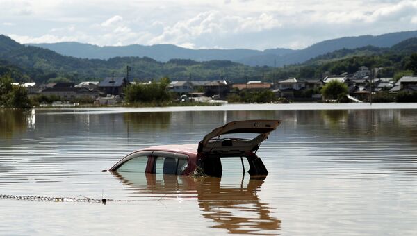 Затопленный автомобиль в городе Курасики, префектура Окаяма, Япония. 8 июля 2018 года