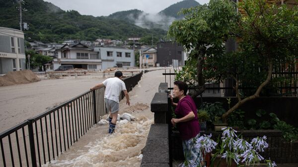 Местные жители во время наводнения в префектуре Хиросима, Япония. 8 июля 2018 года