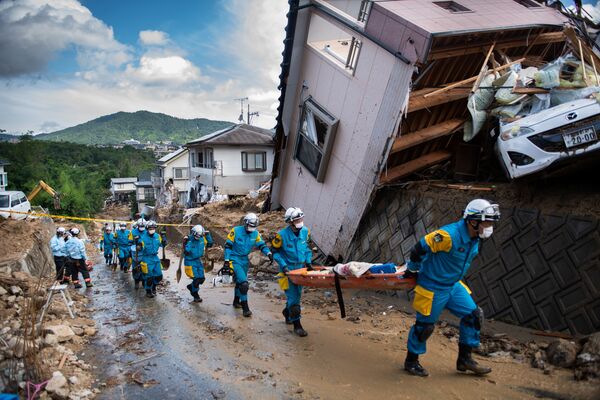 Спасатели в районе наводнения в Кумано, префектура Хиросима, Япония. 9 июля 2018 года