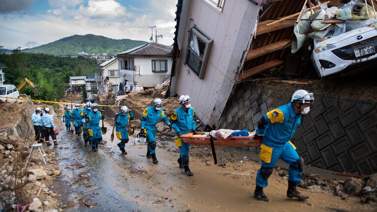 Спасатели в районе наводнения в Кумано, префектура Хиросима, Япония. 9 июля 2018 года