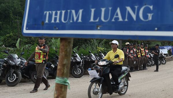 Тайские полицейские охраняют дорогу, ведущую к пещерной зоне Тхам Луанг, пока спасательная операция по вызволению детей продолжается. 9 июля 2018