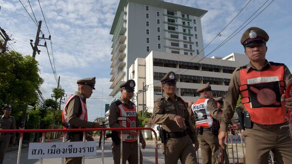 Тайские полицейские блокируют дорогу, ведущую в больницу, куда были доставлены ребята, спасенные  из пещеры Тхам Луанг. 9 июля 2018
