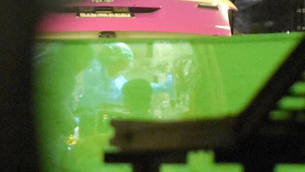 Машина скорой помощи, задействованная в экстренной эвакуации члена детской футбольной команды, просматривается через зеленый брезент по прибытии в больницу в северном тайском городе Чианг Рай. 9 июля 2018