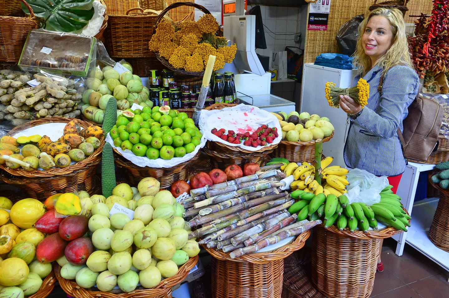Покупательница выбирает фрукты и сахарный тростник